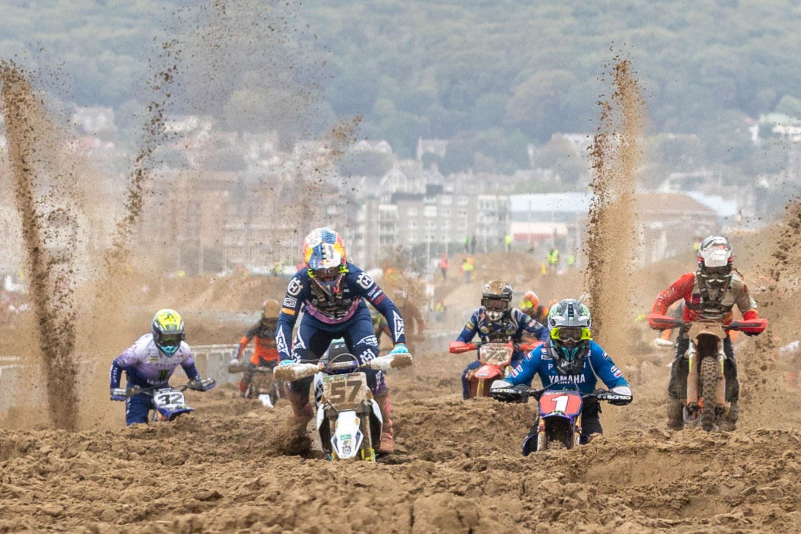 Sand sprays high in the air behind the motorbikes in the Weston-super-Mare Beach Race